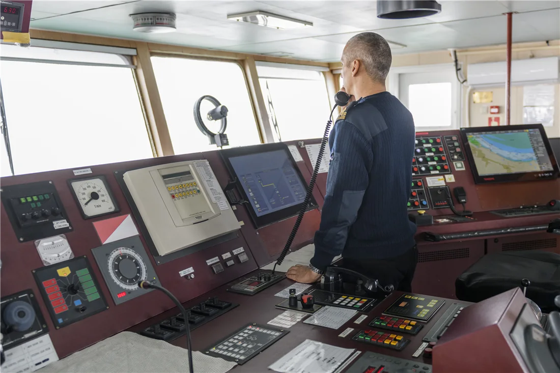 Navigation officer coordinating by radio on the bridge